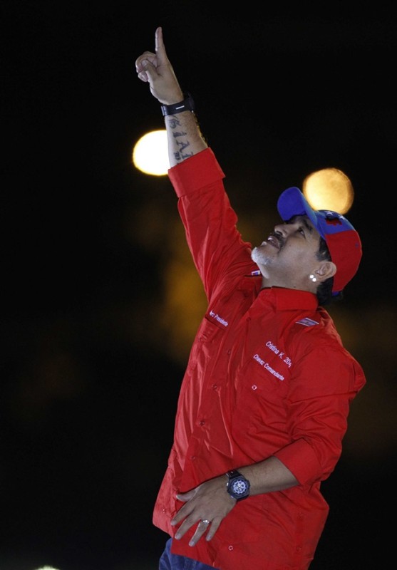 Former Argentine soccer star Maradona points to the sky as he remembers Venezuela's late President Chavez during the closing campaign rally of Venezuela's acting President and presidential candidate Maduro in Caracas