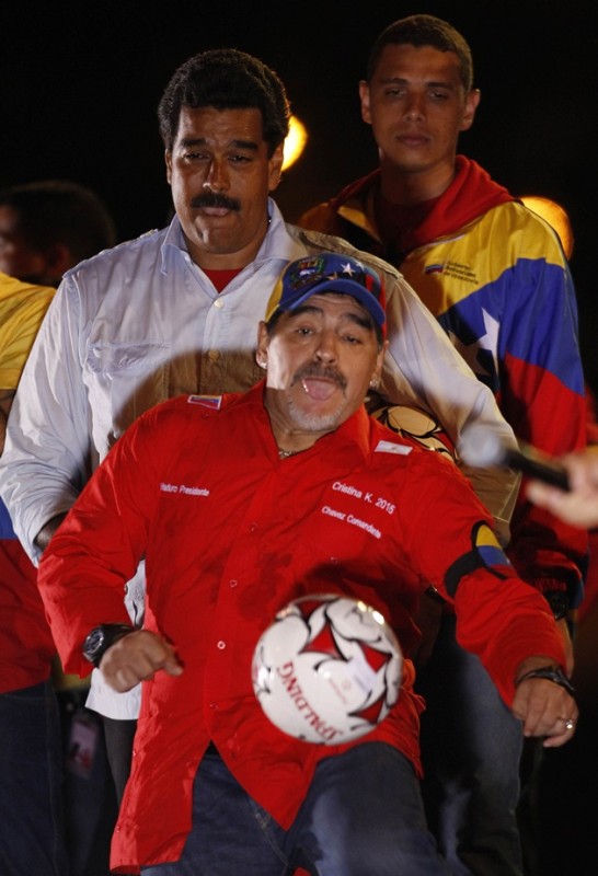 Venezuela's acting President and presidential candidate Maduro watches former Argentine soccer star Maradona kick a ball during his closing campaign rally in Caracas