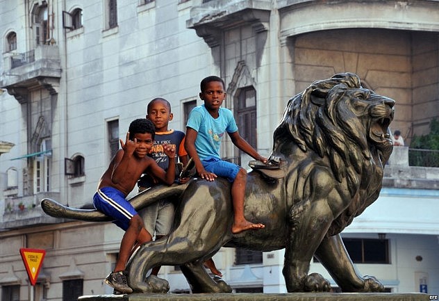 Niños juegan sobre uno de los leones del Paseo del Prado de La Habana (Foto: Agencias)