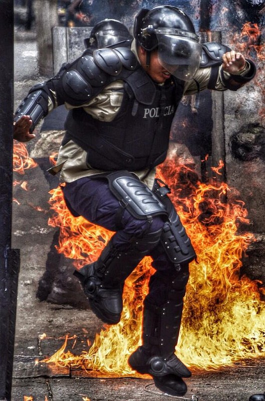 Efectivo de la PNB se protege de las llamas por bombas molotov lanzadas por opositores en Chacao
