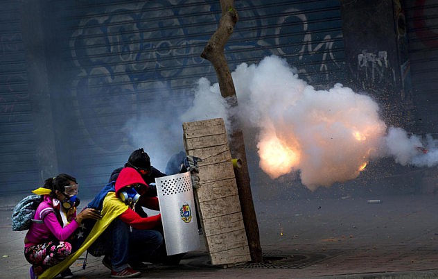 Opositores encapuchados disparan cohetones contra la Policía Nacional Bolivariana este jueves 17 de abril en Chacao. (AP Photo/Ramon Espinosa)