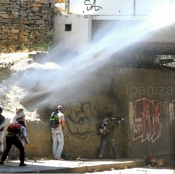 En Bello Monte. Foto: Isaac Paniza. Su leyenda: "Mientras unos reciben agua otro se prepara para dar fuegos artificiales"