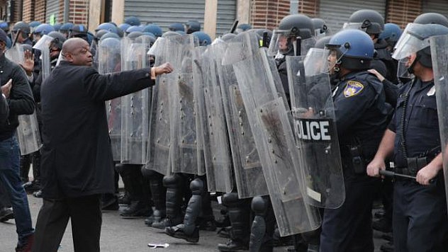 BALTIMORE, MD - APRIL 27:  A demonstrator faces off with a line of Baltimore Police officers at the corner of Pennsylvania and North avenues during violent protests following the funeral of Freddie Gray April 27, 2015 in Baltimore, Maryland. Gray, 25, who was arrested for possessing a switch blade knife April 12 outside the Gilmor Homes housing project on Baltimore's west side. According to his attorney, Gray died a week later in the hospital from a severe spinal cord injury he received while in police custody.  (Photo by Chip Somodevilla/Getty Images)
