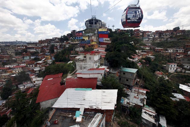 Commuters travel in a Metrocable cabin over the barrio of San Agustin in Caracas September 2, 2010. The Caracas Metrocable cable car operatates over 1.8 km (0.93 miles) with five stops through the upper slum districts of the city center with a capacity to carry 15,000 passengers per day. REUTERS/Jorge Silva (VENEZUELA - Tags: TRANSPORT CITYSCAPE)