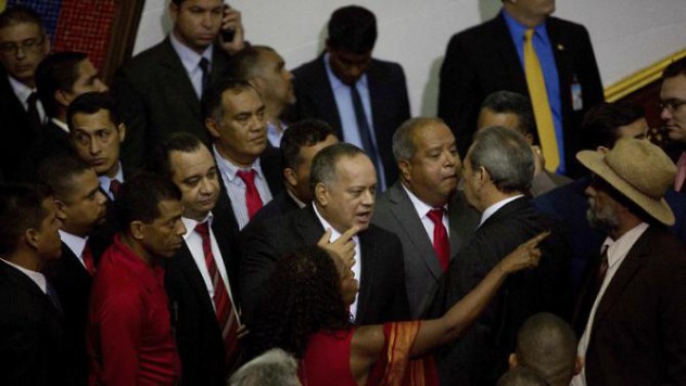 Diosdado Cabello, outgoing parliamentary president, center, and fellow legislators walk out in protest from the National Assembly in Caracas, Venezuela, Tuesday, Jan. 5, 2016. Venezuela's opposition was sworn in Tuesday as the majority in the National Assembly. The lawmakers were sworn in during a heated parliamentary session that saw pro-government representatives walk out in protest after pushing and shoving their way onto the dais as the new leadership laid out its legislative agenda. (AP Photo/Fernando Llano)