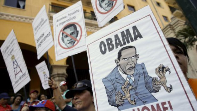Supporters of Venezuela's President Nicolas Maduro hold placards depicting U.S. President Barack Obama during a rally in Caracas, March 12, 2016. REUTERS/Carlos Garcia Rawlins
