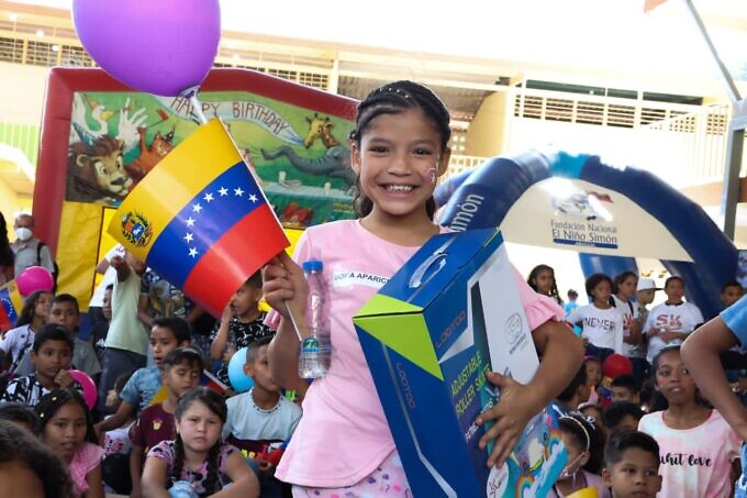 A child in Las Tejerías, with her Christmas gift in one hand and the Venezuelan flag in the other. Photo: Twitter/@ViceVenezuela.